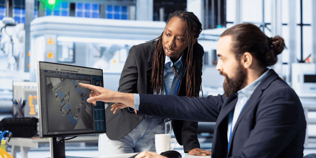 Two professionals in business attire collaborating on a computer, focused on their work.